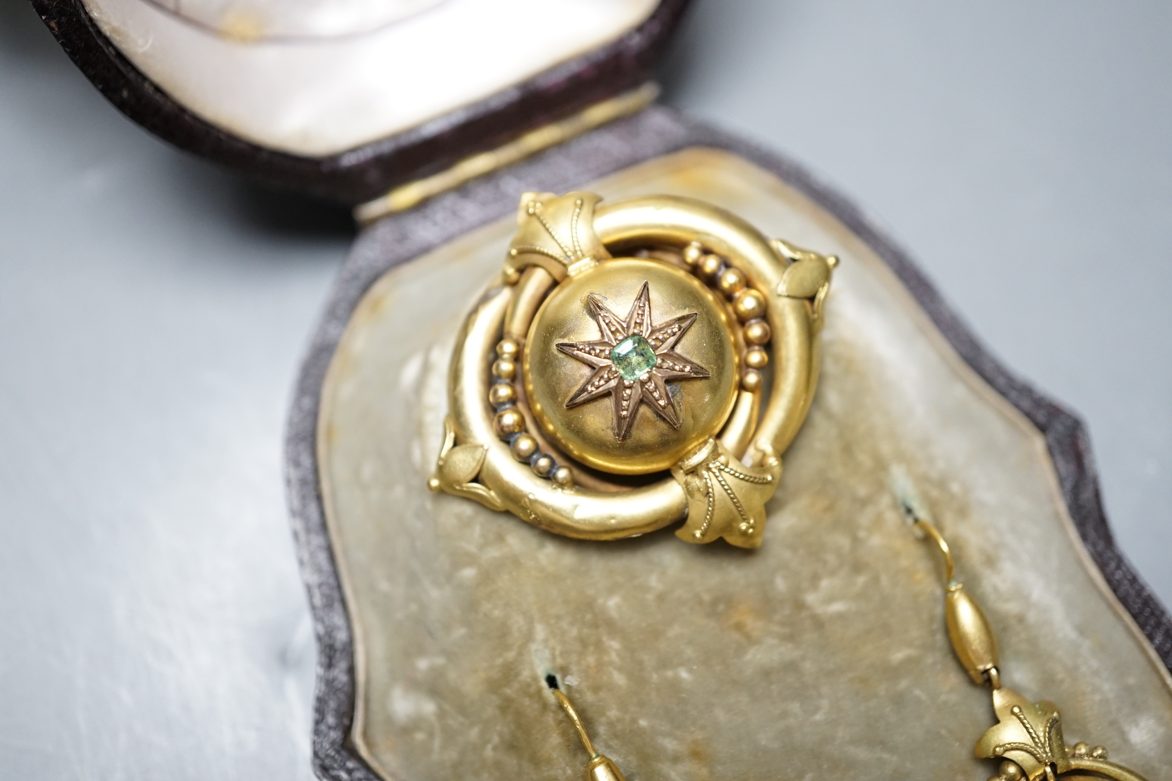 A cased Victorian yellow metal and emerald? set demi parure, comprising a brooch and pair of drop earrings, brooch width 41mm, gross weight 10.8 grams.